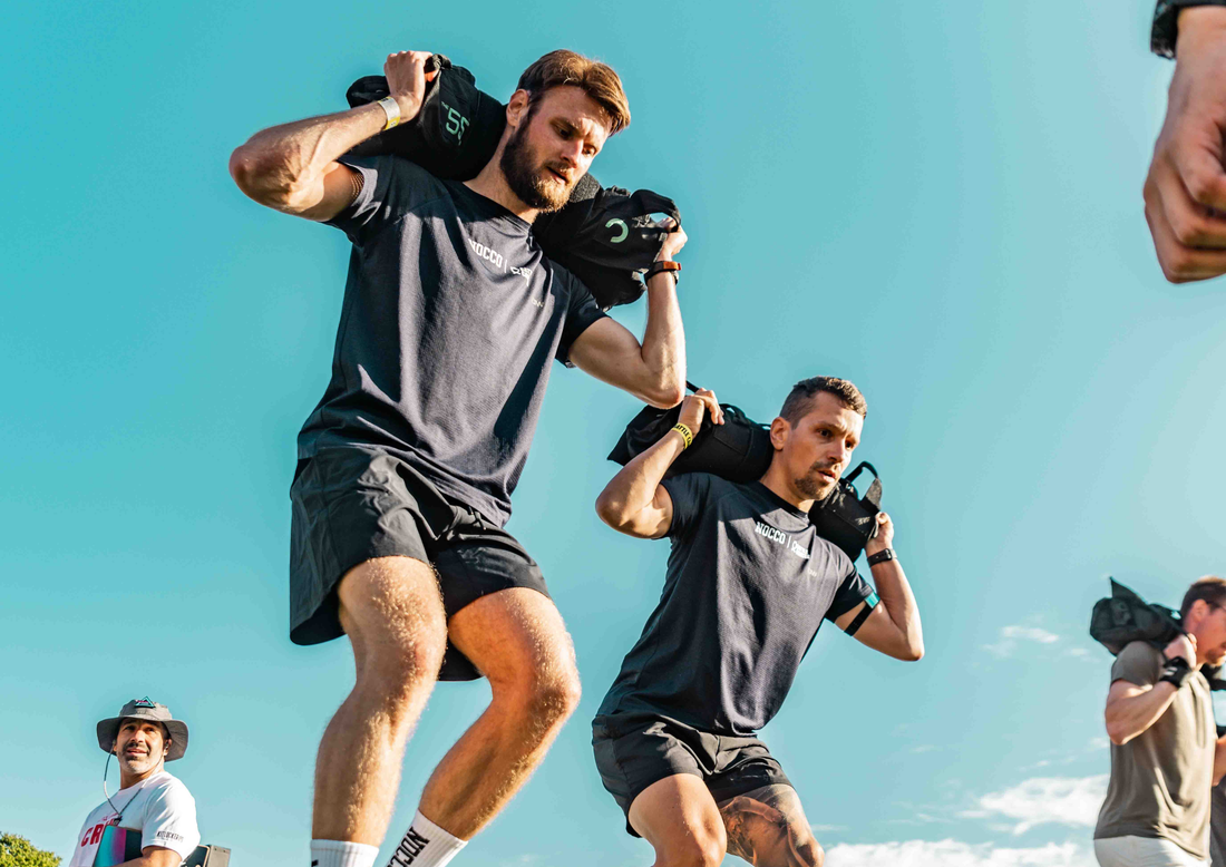 Sandbag training workout for men over 40, demonstrating functional strength, stability, and full-body fitness with a weighted sandbag in an outdoor setting.